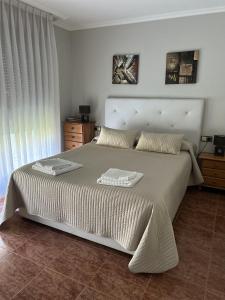 1 dormitorio con 1 cama grande y 2 toallas. en Villa Palmeras, en Llanes