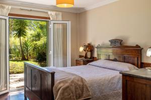 Un dormitorio con una cama y una puerta corrediza de vidrio. en Villa Echium T1, en Caniço