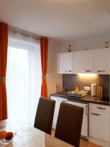 a kitchen with a table and chairs and a window at Apartment Carmen in Nachdemsee