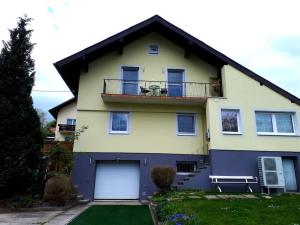 a yellow and blue house with a balcony at Apartment Carmen in Nachdemsee