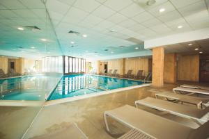 a large swimming pool with chairs in a building at SPA Apartments Perun in Sandanski