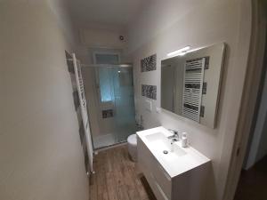bagno con lavandino, servizi igienici e specchio di Le Colonne a Stresa