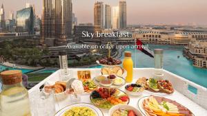 杜拜的住宿－Elite Royal Apartment - Full Burj Khalifa & fountain view - Pearl，阳台上摆放着食物的桌子