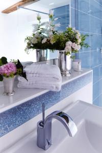 a bathroom with a sink and a mirror and flowers at Romantik Hotel Zum Rosenhof in Hesserode