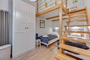 a bedroom with a bunk bed and a bunk ladder at K2018 Mezzo Grand Tourist Apartments in Gdańsk