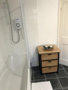 a bathroom with a shower and a wooden cabinet next to a tub at River Terrace in Lancaster