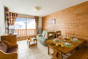 - un salon avec une table et un canapé dans l'établissement Lagrange Vacances L'Arollaie, à Peisey-Nancroix