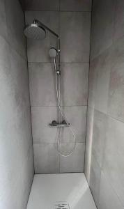 een douche met een douchekop in de badkamer bij Vakantiewoning La Cereza in Opbrakel