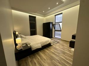 a bedroom with a bed and a window at 3 Bedroom Apartment in Riyadh