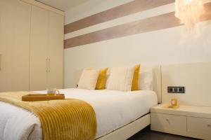 Un dormitorio con una cama grande con almohadas amarillas y blancas en Tauste Centro - Piso, en Tauste
