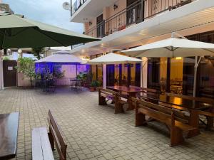 patio ze stołami i parasolami w budynku w obiekcie Hotel Calypso w mieście Suchumi