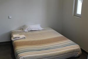 Una cama en una habitación con una manta. en Hôtel et Restaurant de la Gare Torigny-les-Villes, en Torigni-sur-Vire