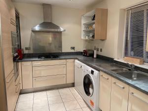 a kitchen with a sink and a washing machine at Ground Main Door with Private Parking in St. Andrews