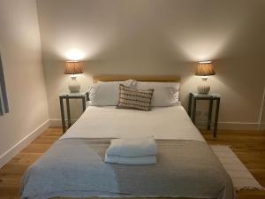 a bedroom with a large white bed with two lamps at Ground Main Door with Private Parking in St. Andrews