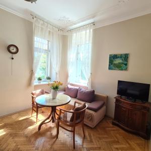 sala de estar con mesa y sofá en Apartmány vila Liberty en Karlovy Vary