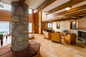 ein großes Wohnzimmer mit einer Steinsäule in der Unterkunft Lagrange Vacances L'Arollaie in Peisey-Nancroix