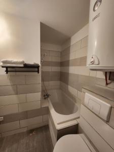 y baño con aseo y bañera. en Agréable appartement, lumineux, en Bar-le-Duc