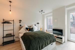 a bedroom with a bed and a flat screen tv at Düsseldorf Boutique-Style Studioapartments in Düsseldorf