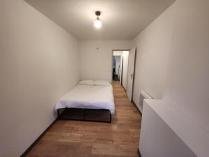 - une petite chambre avec un lit et un couloir dans l'établissement Agréable appartement, lumineux, à Bar-le-Duc