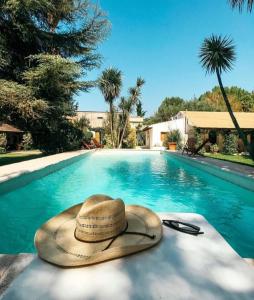 a straw hat sitting next to a swimming pool at Casa de Coria in Chacras de Coria
