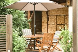 a wooden table with two chairs and an umbrella at Villa B - Neuer Geist in alten Mauern: luxuriös Wohnen in der Residenzstadt Gotha in Gotha