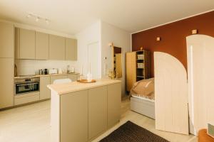 a kitchen with white cabinets and a bed in it at Düsseldorf Boutique-Style Studioapartments in Düsseldorf