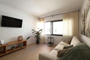 a living room with a couch and a flat screen tv at FLORIT FLATS - The Apolo Apartment in Valencia