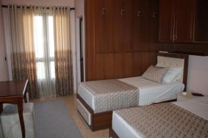 1 dormitorio con 2 camas, mesa y escritorio en Hotel Hasmegaj, en Mjedë