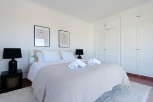 Un dormitorio blanco con una cama con toallas. en Casa Alejandro, en Marbella