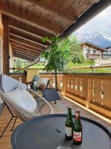 a patio with a table and two bottles of beer at Studio mit großer Loggia in Saalfelden am Steinernen Meer