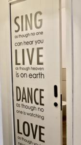 a door with the words sing as though no one can hear you live as though at La tua Kimera in Rozzano