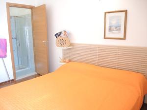 ビビオーネにあるCondominio Bilobaのベッドルーム1室(オレンジ色のベッドカバー付)