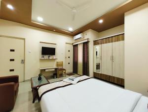a bedroom with a large white bed and a desk at Bluemoon Comforts in Bangalore