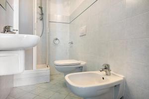 a white bathroom with a toilet and a sink at Bilocale Serra in Bonassola