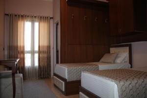 pokój hotelowy z 2 łóżkami i oknem w obiekcie Hotel Hasmegaj w mieście Mjedë
