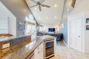 a large kitchen with a ceiling fan and a living room at Castle in the Sand 453 in Avon