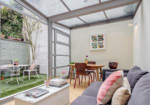 uma sala de estar com um sofá e uma mesa em Notting Hill London - Chic Bright Apartment W11 em Londres