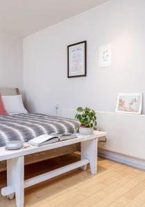 1 dormitorio con 1 cama y 1 mesa con libros en Notting Hill London - Chic Bright Apartment W11, en Londres