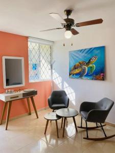 sala de estar con 2 sillas, mesa y TV en Casa ideal vacaciones o trabajo, en Santa Marta