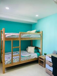 2 literas en una habitación con una pared azul en Casa ideal vacaciones o trabajo, en Santa Marta