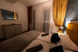 ein Schlafzimmer mit einem Bett, einer Kommode und einem Fenster in der Unterkunft Prime Apartments City Center in Suceava