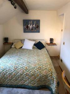 1 dormitorio con 1 cama con un edredón colorido en Tranquil 3-Bed Cottage Near Lake Vyrnwy en Hirnant