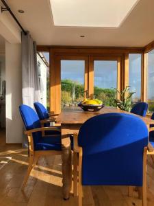 a dining room with a wooden table and blue chairs at Tranquil 3-Bed Cottage Near Lake Vyrnwy in Hirnant