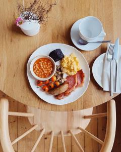 a plate of breakfast food on a wooden table at Coed Mawr Hall Bed & Breakfast in Conwy +34 photos