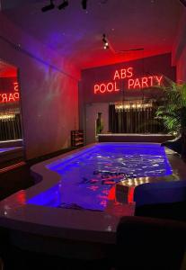 ABS Pool Condo في نانوان: غرفة مع حفلة مسبح مع أضواء أرجوانية