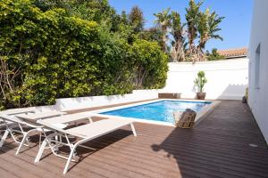 une terrasse avec une piscine, une table et des chaises dans l'établissement Villa Madrugada, beachside villa in Costabella, à Marbella