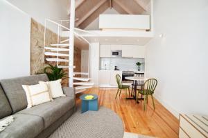 a living room with a couch and a table with chairs at Pause Apartments in Porto