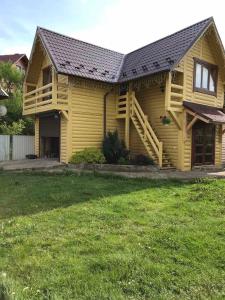 una casa amarilla con un gran patio delante en Модрина, en Vorokhta