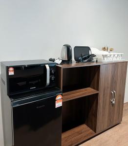 a kitchen with a black microwave and a wooden cabinet at Geo Suite - Sunway Pyramid & Sunway Lagoon in Petaling Jaya