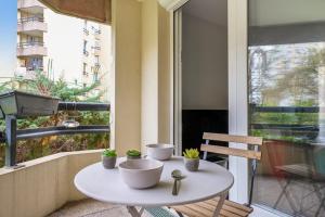 a white table on a balcony with plants on it at Charming 1br with terrace close to Paris - Asnières - Welkeys in Asnières-sur-Seine
